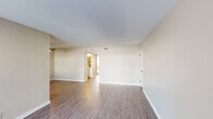 Located on Zelzah Avenue in the Northridge neighborhood of Los Angeles, this single-story unit offers a clean, functional layout spread across several well-defined living spaces. The main living area is generously proportioned, featuring durable wood-style flooring, neutral beige walls, and a ceiling fan, creating a comfortable and versatile space. Built-in shelving adds a practical design detail, while a sliding glass door draws in natural light and provides outdoor access.

The kitchen is efficiently arranged in an L-shaped configuration, outfitted with white cabinetry featuring matte black hardware, light countertops, and a full suite of stainless steel appliances including a gas range, over-the-range microwave, and refrigerator. A window above the sink allows natural light to brighten the workspace.

The bedrooms are carpeted for comfort and each features a window with vertical blinds that filter in ample daylight. The bathroom includes a tub-shower combination with sliding glass doors, a single-sink vanity with white cabinetry, and wood-style flooring. Mirrored closet doors in the bedroom area reflect light and contribute to a sense of spaciousness throughout the unit.