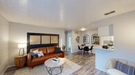 This 1-bedroom, 1-bathroom unit at 518 Tacoma Dr in Garland, TX offers a thoughtfully designed, single-floor layout that maximizes every inch of its compact footprint. The open-concept living and dining area flows seamlessly together, anchored by wood-look plank flooring, neutral gray walls, and a textured ceiling. The living room features a bright window with sheer curtains, allowing natural light to fill the space. Adjacent to the living area, the dining space is distinguished by a pair of arched black-framed mirror panels and decorative wall art, adding a stylish focal point. The galley-style kitchen is equipped with stainless steel appliances including a refrigerator and dishwasher, white cabinetry, a subway tile backsplash, and a light quartz countertop that extends to a peninsula breakfast bar. The bedroom is a comfortable retreat with a ceiling fan, a window with natural light, and direct access to a dedicated closet. The bathroom includes a full tub-shower combination. Wood-look flooring runs consistently throughout the unit, tying all spaces together with a cohesive, modern aesthetic. The layout is efficient and well-organized, making it a functional and stylish living space.