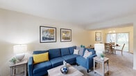 Located at 3769 Brice Run Rd in Randallstown, Maryland, this two-floor residence offers a well-organized layout designed for comfortable everyday living. The main level centers around a generously sized living room with neutral walls, carpet flooring, and a front-facing window that draws in natural light. A staircase leads to the upper level, and the open flow connects seamlessly to the adjoining spaces. The dining area is a standout feature, highlighted by a classic chandelier overhead and a large sliding glass door that frames outdoor greenery, creating a bright and inviting atmosphere for meals. The kitchen is efficiently laid out with warm oak cabinetry, white appliances including a gas range, dishwasher, microwave, and refrigerator, along with a double sink and light vinyl flooring. The bedrooms are carpeted and filled with natural light from multiple windows, offering a calm and restful environment with ample closet access. The bathroom features a tub-shower combination with classic white tile surround, a single vanity with wood cabinetry, and a large mirror. Overall, the home presents a clean, functional aesthetic throughout both floors.