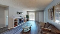 This single-story apartment at 2929 Routine Rd in Rancho Cordova, California, offers a well-organized layout across several functional living spaces. The living room serves as the focal point of the unit, anchored by a striking tile-surround fireplace framed by built-in shelving on either side. Wood-look flooring runs throughout, and a sliding glass door leads to an outdoor balcony, allowing natural light to fill the space. A textured ceiling adds dimension to the room.

Adjacent to the living room is a dedicated dining area, equipped with a ceiling fan and room for a full-size dining table, making it practical for everyday meals or entertaining.

The galley-style kitchen is efficiently designed with white cabinetry lining both sides, light quartz-style countertops, a stainless steel refrigerator, and an electric range. A double sink sits beneath upper cabinets on one wall, maximizing storage and workspace.

The bedrooms feature plush carpeting, natural light from outdoor-facing windows, and textured ceilings. Both bathrooms include a tub-shower combination, wood-look flooring, warm neutral walls, and white cabinetry with light countertops, providing clean and functional spaces.