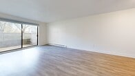Located at 55 Bay St in Victoria, BC, this one-bedroom, one-bathroom unit offers a thoughtfully laid-out single-floor design with a clean, contemporary aesthetic throughout. Light-toned laminate flooring flows seamlessly across the living, dining, and sleeping areas, contributing to a bright and cohesive feel. The spacious living room is a standout feature, with two sliding glass doors that invite natural light and provide access to an outdoor patio area, creating an easy indoor-outdoor connection. A baseboard heating system runs along the perimeter of the living space for efficient climate control. The kitchen is well-appointed with white shaker-style cabinetry, a classic subway tile backsplash, dark countertops, a stainless steel sink with a modern faucet, and a stainless steel dishwasher. A stove is also present, making the kitchen fully functional. The bedroom offers a comfortable footprint with a built-in sliding door closet and warm laminate flooring. The bathroom features large-format floor tiles, a full soaker tub with white subway tile surround, a white vanity, and chrome fixtures, giving it a clean, timeless appearance. The textured ceilings and crisp white walls throughout add to the unit's fresh, move-in-ready presentation.