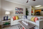 This single-story residence located in Overland Park, Kansas, offers a thoughtfully designed layout that balances comfort and functionality. The living room serves as the heart of the home, featuring crown molding, ceiling fan, and plush carpeting. A sliding glass door admits generous natural light and provides outdoor access. The space flows seamlessly toward a dedicated dining area, illuminated by a pendant light fixture and positioned conveniently adjacent to the kitchen.

The kitchen is well-equipped with warm wood cabinetry, granite-style countertops, stainless steel appliances including a refrigerator, range, and built-in microwave, and wood-style flooring that adds a polished finish.

Multiple bedrooms offer carpeted floors, ceiling fans, and windows dressed with curtains for privacy and light control. The primary bedroom includes direct access to an en-suite bathroom, while additional bedrooms are generously sized with ample natural light.

The bathrooms feature wood-style flooring, vanities with extended countertops and under-sink cabinetry, and tub-shower combinations with tile surrounds. Neutral tones throughout the unit create a cohesive, inviting atmosphere well-suited for everyday living.