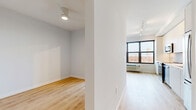 Located at 208 Fourth Ave in Asbury Park, NJ, this 1-bedroom, 1-bathroom unit offers a clean, modern aesthetic across a single well-organized floor. Light hardwood flooring runs throughout, complementing crisp white walls and creating a bright, cohesive atmosphere.

The entrance leads into a corridor that connects the main living spaces. The open-plan area seamlessly combines the living room, dining space, and kitchen into one flowing zone. The kitchen is a standout feature, outfitted with sleek flat-front white cabinetry extending to the ceiling, stainless steel appliances including a range, microwave, dishwasher, and refrigerator, and a subtle tile backsplash for added texture. A large picture window anchors the living area, framing elevated views of the surrounding Asbury Park cityscape and flooding the space with natural light. A wall-mounted HVAC unit and track lighting round out the practical details.

The bedroom is a calm, well-proportioned retreat with a ceiling fan and direct sightlines to the main living area. Two closets provide ample storage. The bathroom is finished to a high standard, featuring large-format marble-look tile flooring, a floating wood-toned vanity with an undermount sink and wide mirror, and a glass-enclosed walk-in shower. An in-unit laundry area and utility room add convenience to this thoughtfully designed residence.