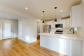 Located at 192 E Kellogg Road in Bellingham, Washington, this three-bedroom, four-bathroom home is thoughtfully arranged across three floors, offering a well-organized layout with generous closet space throughout. The main level features a bright, open-concept living, dining, and kitchen area bathed in natural light from large windows and a sliding glass door that opens to a private deck with outdoor views. The kitchen is outfitted with crisp white shaker cabinetry, light quartz countertops, stainless steel appliances including a refrigerator, electric range, and built-in microwave, and a peninsula that doubles as a breakfast bar. Warm-toned luxury vinyl plank flooring runs throughout the main and lower levels, while bedrooms feature plush carpeting for added comfort. A mini-split system provides efficient climate control. The upper floor hosts the primary bedroom, distinguished by vaulted ceilings and a window framing views of the surrounding greenery, lending an airy, retreat-like feel. Additional bedrooms are bright and well-proportioned, each with ample closet space. Four full bathrooms are cleanly finished with neutral tones. The home's modern, move-in-ready interior is complemented by a clean, contemporary exterior, making it a practical and polished residence in Bellingham.