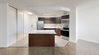 Located on the sixth floor at 3122 Hurontario Street in Mississauga, Unit 603 is a well-appointed one-bedroom, one-bathroom residence offering a practical and functional layout across a single floor. The unit is accessed through a dedicated entrance that leads into a hallway with ample storage provided by multiple closets, keeping the living areas neat and organized.

The kitchen is a standout feature, showcasing rich dark-wood cabinetry, a herringbone tile backsplash, white quartz countertops, and a full suite of stainless steel appliances including a refrigerator, electric range, microwave, and dishwasher. A central island with matching cabinetry provides additional prep and storage space while seamlessly connecting the kitchen to the open-concept dining and living area. Parquet hardwood flooring runs through the living space, adding warmth and character.

The bedroom is a comfortable, light-filled room featuring a large window that brings in natural light and parquet flooring. The bathroom is finished with large-format beige wall tiles surrounding the soaker tub and shower, complemented by tile flooring and a dark-wood vanity.

A private balcony extends the living space outdoors, offering open views of the surrounding Mississauga cityscape and Hurontario Street corridor.