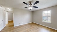 This 2-bedroom, 1-bathroom home in Clarksville, Tennessee offers a practical and well-maintained single-floor layout with a clean, neutral aesthetic throughout. Light wood-tone flooring runs continuously across the living spaces, complementing the warm gray walls and crisp white trim found in every room.

The living area provides a comfortable gathering space that flows into the kitchen, which is thoughtfully equipped with white cabinetry, granite-look countertops, a stainless steel refrigerator, range, microwave, and dishwasher — offering a modern, functional cooking environment.

Both bedrooms feature ceiling fans with light kits, windows that allow natural light to filter in, and ample closet storage. The primary bedroom includes two dedicated closet doors, while the second bedroom offers a built-in closet with bifold doors. The textured ceilings add subtle character throughout the rooms.

The full bathroom is neatly appointed with a dark-cabinetry vanity with white countertop, a tub-shower combination, and the same light wood flooring that carries throughout the home.

Overall, the space presents a cohesive, move-in-ready feel with consistent finishes, practical storage solutions, and a bright, understated atmosphere well-suited for comfortable everyday living.