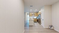 Located at 4741 Hoffner Ave in Orlando, FL, this well-appointed single-floor residence offers three bedrooms, three bathrooms, and three closets within a thoughtfully designed layout. Light-toned wood-style flooring runs throughout, lending a clean, cohesive aesthetic to every room.

The open-concept kitchen and living area serves as the heart of the home. The kitchen features warm wood cabinetry with open shelving, white quartz countertops, stainless steel appliances, recessed lighting, and a central island that provides additional workspace and casual seating. The living area flows naturally from the kitchen and is filled with natural light from large windows fitted with blinds.

Each bedroom is finished with the same light wood flooring and includes a ceiling fan. The primary bedroom is a generously sized retreat with access to a private outdoor area through a glass door, offering views of the outdoors. Additional bedrooms feature large windows and ceiling fans, creating bright, comfortable spaces. Each bedroom benefits from dedicated closet space, including a walk-in closet with wire shelving for ample storage.

The bathrooms are finished with elegant marble-style tile surrounds in the tub and shower areas. The neutral, light color palette used throughout the home creates a calm, airy ambiance that complements the modern design.