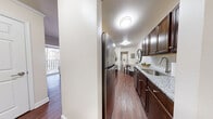 Located on Colonnade Drive in Charlottesville, Virginia, this single-floor residence offers a thoughtfully designed layout with a cohesive, modern aesthetic throughout. The galley-style kitchen is a standout feature, equipped with rich dark wood cabinetry, granite countertops, a subway tile backsplash, and a full suite of stainless steel appliances including a refrigerator, range, microwave, and dishwasher. Durable hardwood-style flooring runs through the kitchen and living areas, adding warmth and continuity to the space.

The living room is generously sized and filled with natural light from a large sliding glass door that opens to a private balcony, offering outdoor access and views of the surrounding area. Crown molding details lend a polished finish to the living space.

Two well-proportioned bedrooms feature plush carpeting, ceiling fans, crown molding, and windows that allow natural light to filter in. Each bedroom provides a comfortable and restful environment.

Two bathrooms serve the residence, each featuring a glass-enclosed walk-in shower, a dark wood vanity with a white countertop, tile flooring, and clean, neutral finishes throughout. The overall design of the home balances functionality with contemporary style, creating a comfortable living environment in a convenient Charlottesville location.