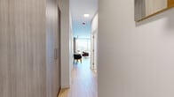 Located in Chicago's vibrant River North neighborhood, this thoughtfully designed studio at 868 N Wells St offers a sleek, modern living experience across a single well-appointed floor. Light hardwood flooring runs throughout, tying together the open-concept layout seamlessly.

The combined kitchen and living area serves as the heart of the space. The kitchen features contemporary flat-panel cabinetry in a warm gray tone, stone countertops, a glossy subway tile backsplash, stainless steel appliances including a gas cooktop, oven, and full-size refrigerator. A dining area with a round table sits adjacent to the kitchen. The living area is anchored by floor-to-ceiling windows that flood the space with abundant natural light and offer sweeping views of the Chicago skyline and surrounding cityscape.

A hallway connects the main living area to the private spaces, flanked by generous built-in storage with sleek cabinetry. The bathroom is finished in neutral tones with large-format floor tiles, a walk-in glass-enclosed shower, and a modern vanity with ample storage. A dedicated laundry room houses a stacked full-size washer and dryer, adding exceptional convenience. The overall ambiance is clean, contemporary, and efficiently designed for comfortable urban living.
