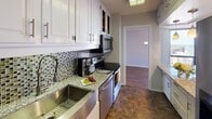 Located in the heart of downtown Minneapolis, this high-rise unit at 1200 S Marquette Ave offers sweeping views of the city skyline from multiple rooms. The layout, as seen in the 3D floor plan, flows from a well-proportioned living area into a dedicated dining space and kitchen, with private sleeping quarters positioned separately for added comfort.

The living room features wood-style plank flooring, a built-in fireplace, and floor-to-ceiling sliding glass doors that open to a balcony, flooding the space with natural light and framing striking urban views. A chandelier over the dining area adds a classic touch.

The kitchen is well-appointed with white cabinetry, granite countertops, a mosaic tile backsplash, stainless steel appliances including an over-the-range microwave and dishwasher, and a deep single-basin sink with a modern faucet. Tile flooring completes the functional workspace.

The bedrooms are carpeted and feature large windows with panoramic downtown views. Mirrored sliding closet doors and track lighting add practical detail to the sleeping areas.

The bathrooms include a full tub-and-shower with white tile surround, and a second bath with granite countertops, pendant lighting, a large mirror, and a separate water closet.