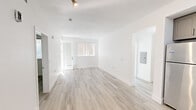 Located on the iconic Sunset Boulevard in the heart of Hollywood, this well-appointed 2-bedroom, 2-bathroom residence offers a clean, modern aesthetic throughout. Light wood-style flooring flows seamlessly across the single-floor layout, complementing the crisp white walls and creating a bright, airy atmosphere.

The open-concept living and kitchen area forms the heart of the home. The kitchen is outfitted with sleek gray shaker cabinets, marble-style quartz countertops, a deep undermount sink, and a full suite of stainless steel appliances, including a refrigerator, range, and over-the-range microwave. The adjacent living room receives abundant natural light and provides direct access to a private balcony.

Both bedrooms are comfortably sized with large windows dressed in vertical blinds that filter in soft, natural light. The primary bedroom offers a generous footprint with ample room for furnishings. A dedicated closet and hallway provide practical storage solutions.

The two bathrooms mirror each other in design, each featuring gray shaker vanities with quartz countertops, tub-shower combinations with white tile surrounds, brushed nickel fixtures, and wood-style flooring. One bathroom includes additional built-in cabinetry for extra storage. The overall design is cohesive, modern, and move-in ready.