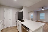 Located at 100 Lenox Park Circle NE in Atlanta, GA, this well-appointed 2-bedroom, 2-bathroom single-story home offers a thoughtfully designed layout across a comfortable footprint. Light-toned hardwood-style flooring runs throughout, complementing the neutral gray and white color palette that gives the home a clean, contemporary feel.

The open-concept kitchen and living area serves as the heart of the home. The kitchen is outfitted with crisp white shaker cabinetry, white quartz countertops, a central island with an undermount sink, and a full suite of stainless steel appliances including a refrigerator, range, microwave, and dishwasher. This space flows naturally into the living area, which features a ceiling fan and windows that invite natural light.

Both bedrooms are generously sized, each equipped with a ceiling fan, hardwood-style flooring, and access to closet space. The primary bedroom offers a notably spacious layout with its own dedicated closet. The two bathrooms feature marble-style surround tiling, soaking tubs, and white vanity cabinetry with light countertops.

Additional highlights include a dedicated laundry area, a utility room, a den, multiple hallways connecting the rooms efficiently, and an impressive eight closets throughout—providing exceptional storage for a home of this size.