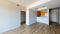 Located at 3707 Motor Ave in the Palms neighborhood of Los Angeles, this single-floor unit offers a clean, functional layout with a cohesive design throughout. Wood-look flooring extends across all areas of the space, providing a warm and consistent aesthetic that ties each room together.

The open living area is generously sized, with neutral gray walls and a ceiling-mounted ventilation system. It flows directly into the kitchen, which is separated by a breakfast bar-style counter. The kitchen is equipped with warm-toned wood cabinetry, a gas range, over-the-range microwave, dishwasher, and refrigerator, all set against a hard-surface countertop and a deep stainless steel sink.

The bedrooms are bright and well-proportioned, each featuring large windows dressed with vertical blinds that allow ample natural light. One bedroom includes a built-in wood shelving unit and a built-in desk, offering a practical workspace. Closet storage is available via sliding-door closets.

The bathroom is finished with wood-look flooring and features a full tub and shower combination enclosed by sliding glass doors, along with a white vanity with under-sink storage and a large wall mirror. A window above the tub provides additional natural light and ventilation. The overall ambiance of the space is clean, neutral, and move-in ready.